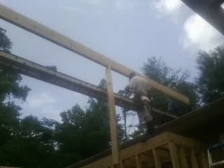 Carpenter setting a ridge beam over a new addition frame — Ice Dam Removal by Roofing Brothers in Stockton