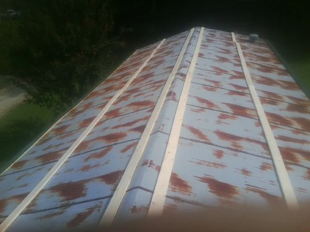 Rusted metal roof panels with new wood purlins before replacement in Stockton